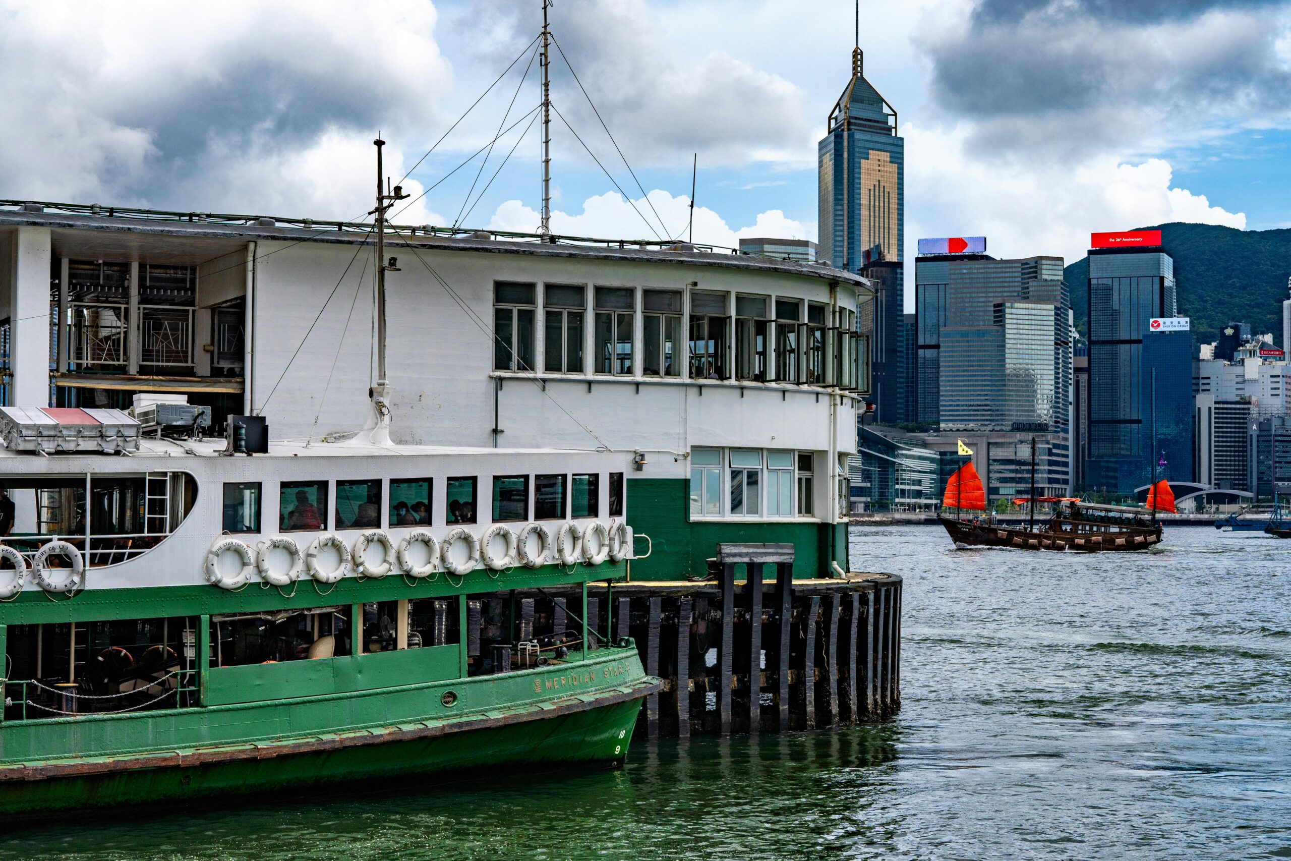 A vibrant scene at the Tsim Sha Tsui Star Ferry Pier capturing a ferry against the city skyline.