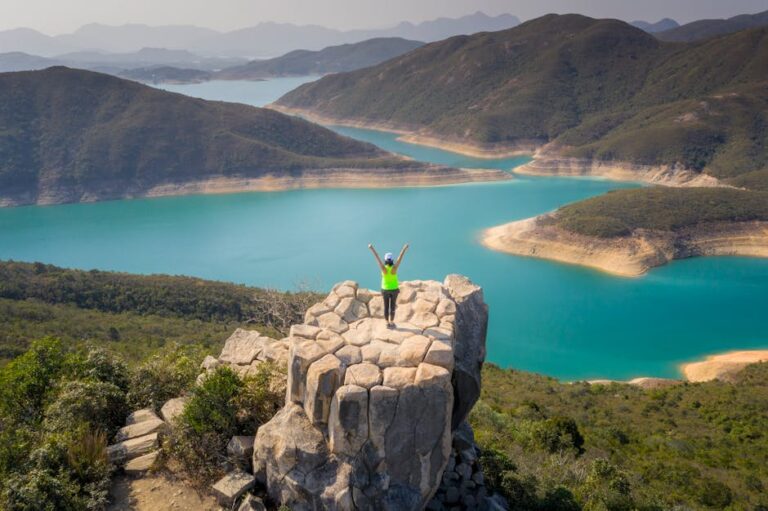 Explore the breathtaking aerial view of a turquoise reservoir in New Territories, Hong Kong, with scenic mountains.